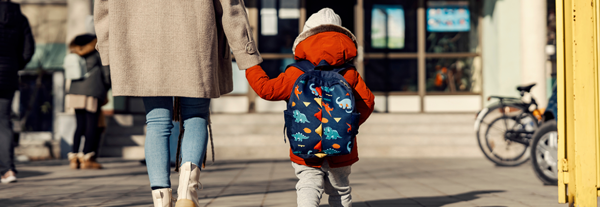 Parent and child walking toward school entrance